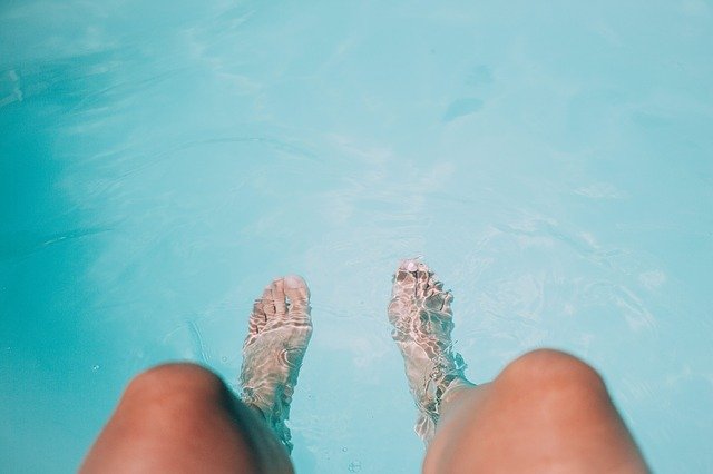 femme avec des jambes bronzées dans l'eau