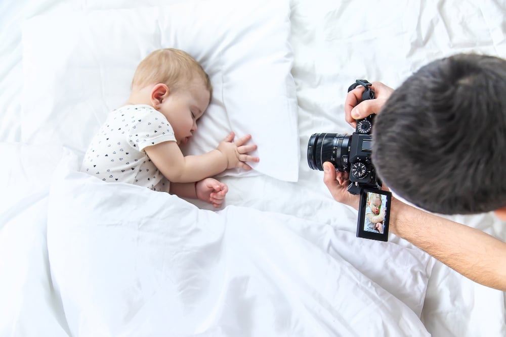 un homme qui photographie un bébé