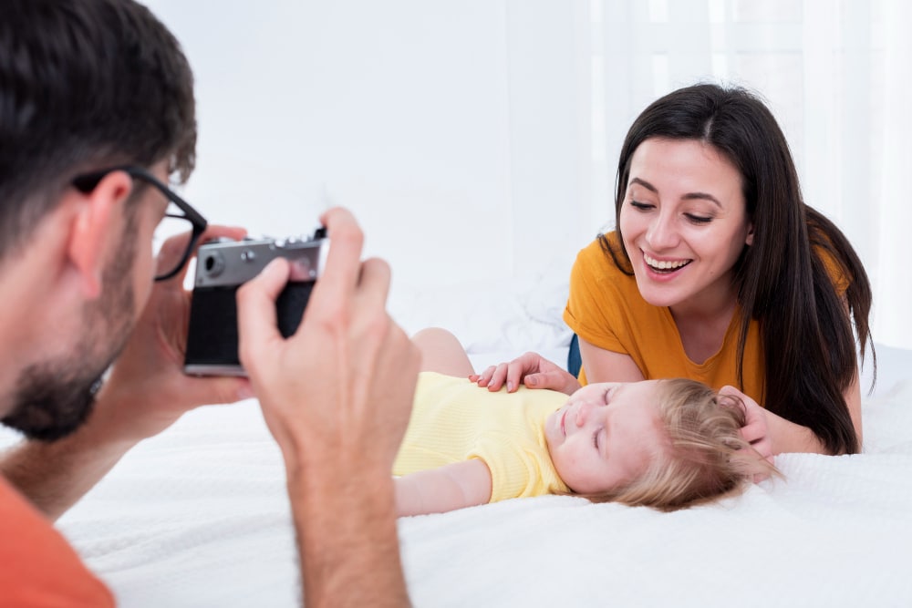 couple qui photographie un jeune enfant